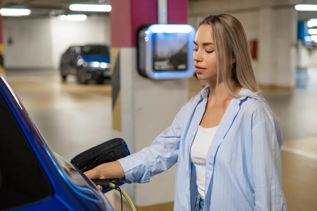 A driver charging their electric vehicle